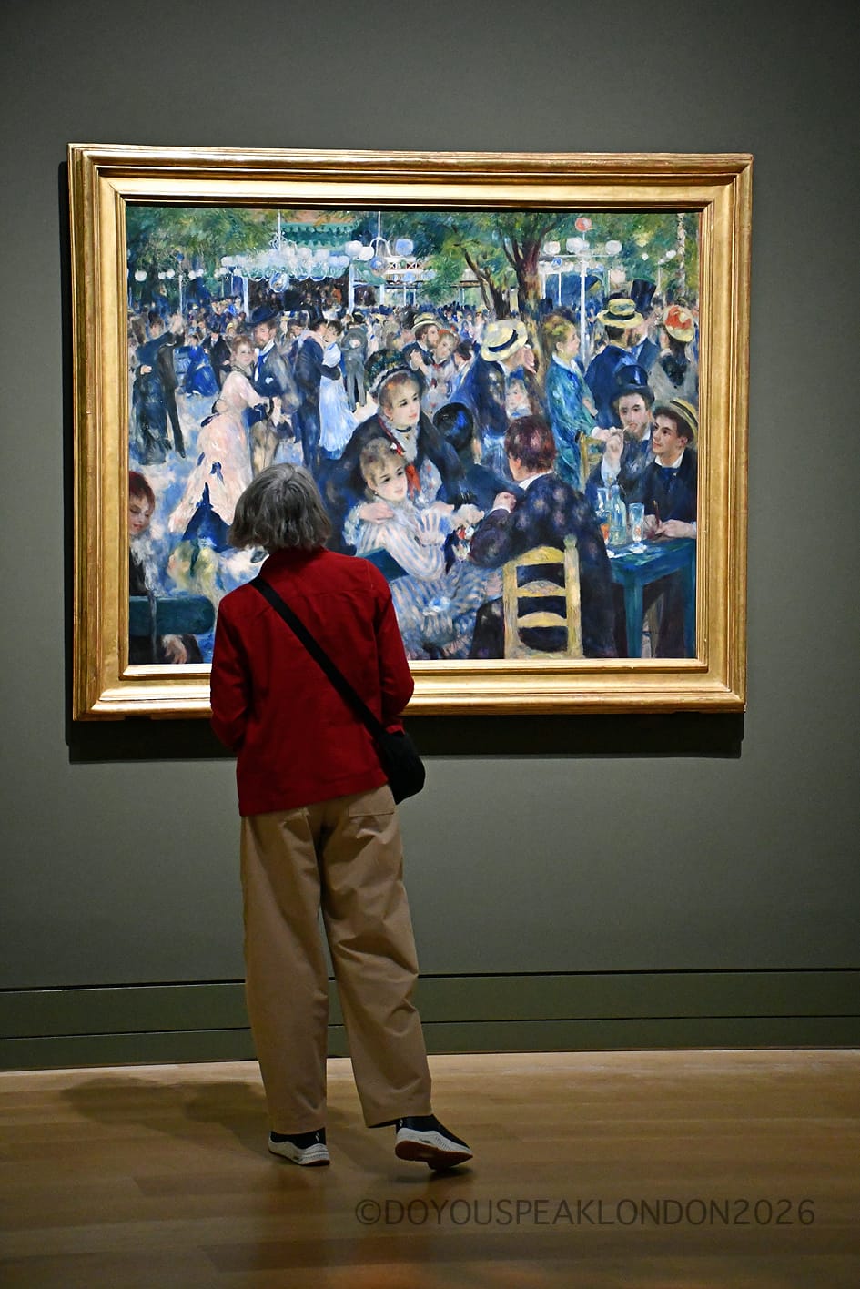 Visitor in front of Renoir's Bal du Moulin de la Galette, shown in the UK for the first time at the National Gallery