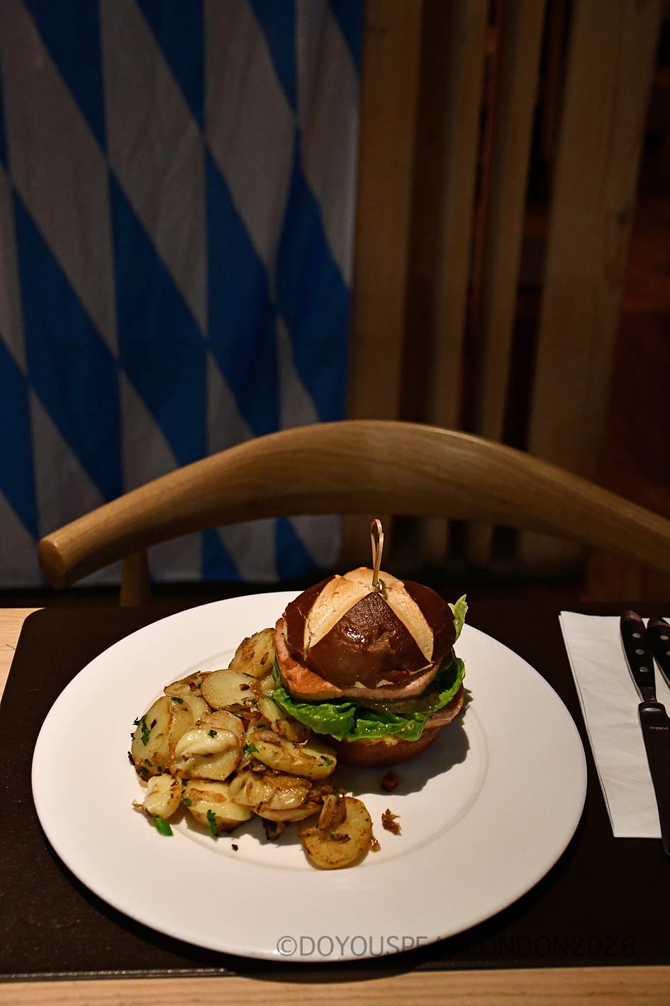 Leberkäse burger in a pretzel bun with pan-fried potatoes at Stein's Berlin