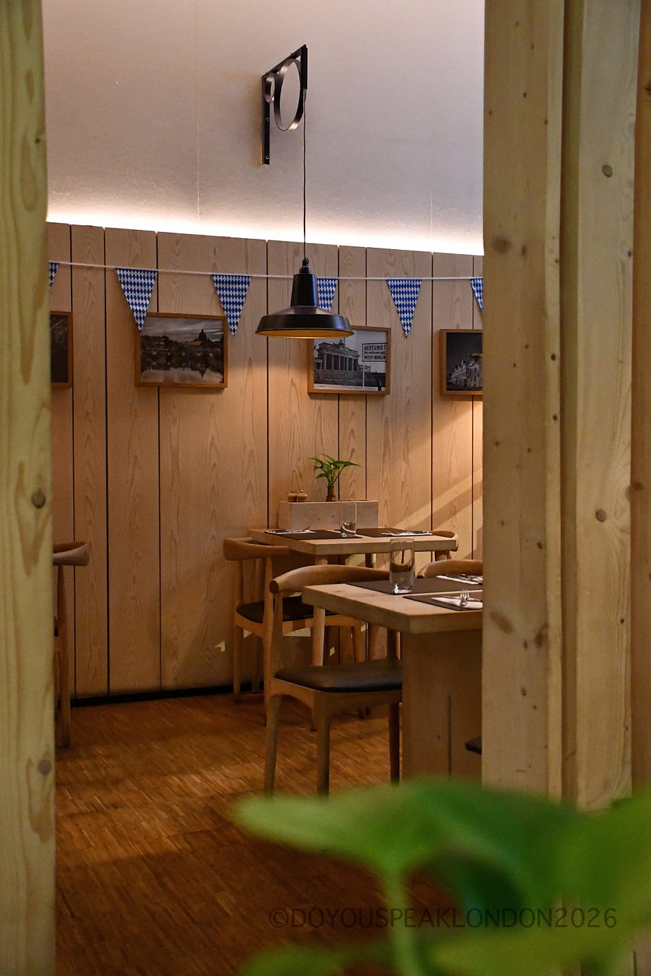A quiet corner with framed photos and pale wood panelling at Stein's Berlin