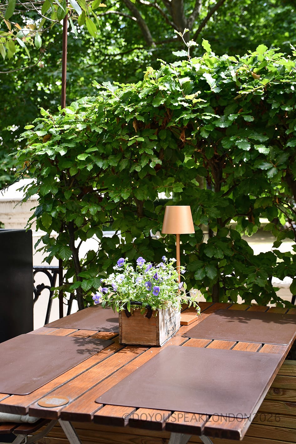 A terrace table with flowers and a gold lamp at Stein's Berlin