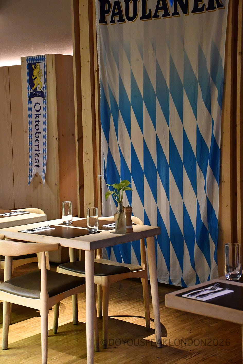 Blue and white Bavarian Paulaner banner beside a small table at Stein's Berlin